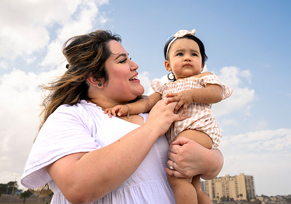Crystal holding her baby daughter, reflecting hope, healing, and life after listening to early heart warning signs.