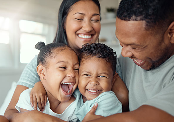 A family of four shares a group hug
